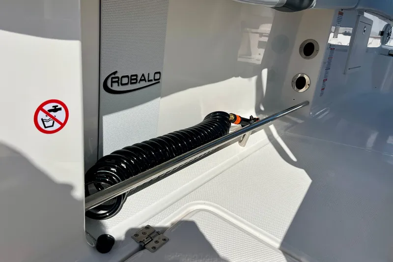 Slide: The Image of 2026 Robalo R270 Center Console boat interior with coiled hose and safety signage. - 26