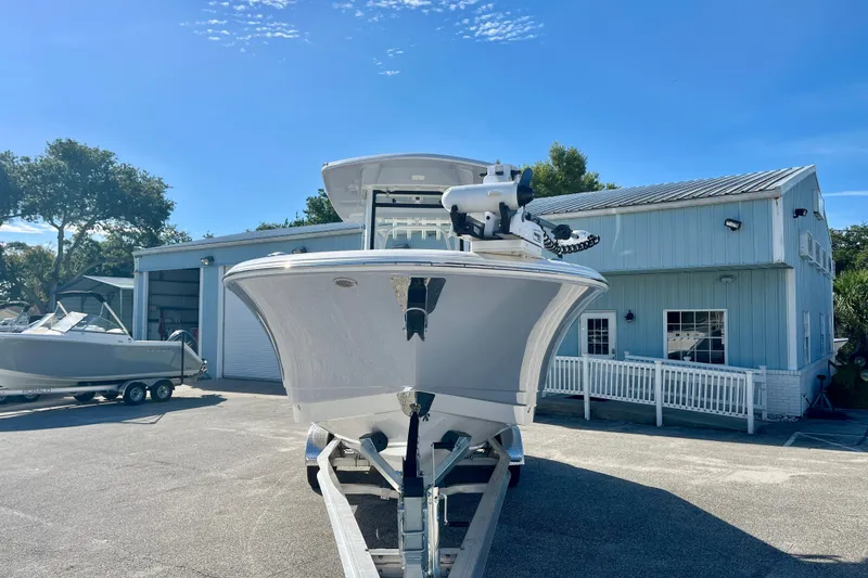 Slide: The Image of 2026 Robalo R270 Center Console boat on trailer outside a blue building. - 3