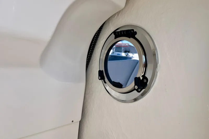 Slide: The Image of 2026 Robalo R270 Center Console boat interior with round porthole detail. - 47