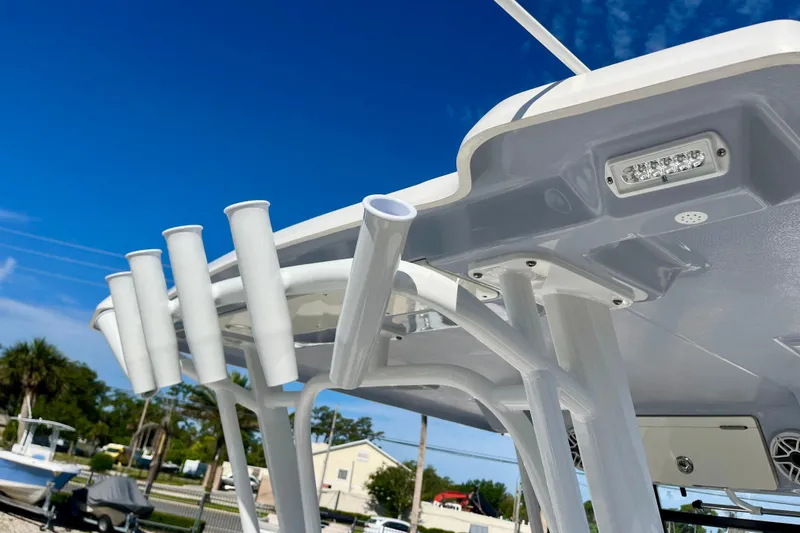 Slide: The Image of 2026 Robalo R270 Center Console boat with rod holders and LED lights under a clear blue sky. - 51