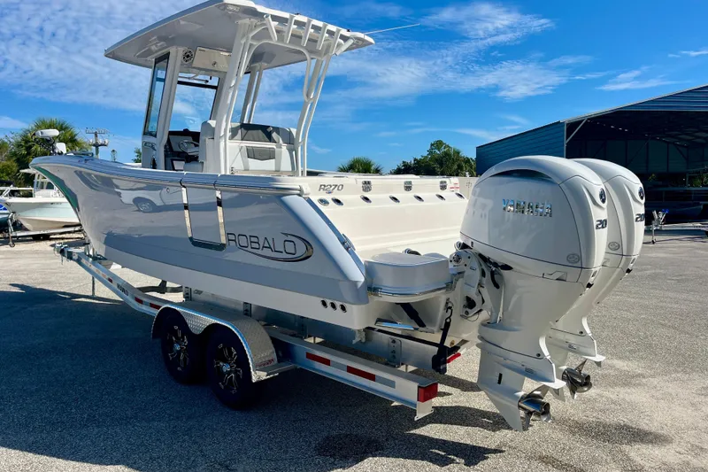 Slide: The Image of 2026 Robalo R270 Center Console boat with dual Yamaha engines on a trailer. - 8