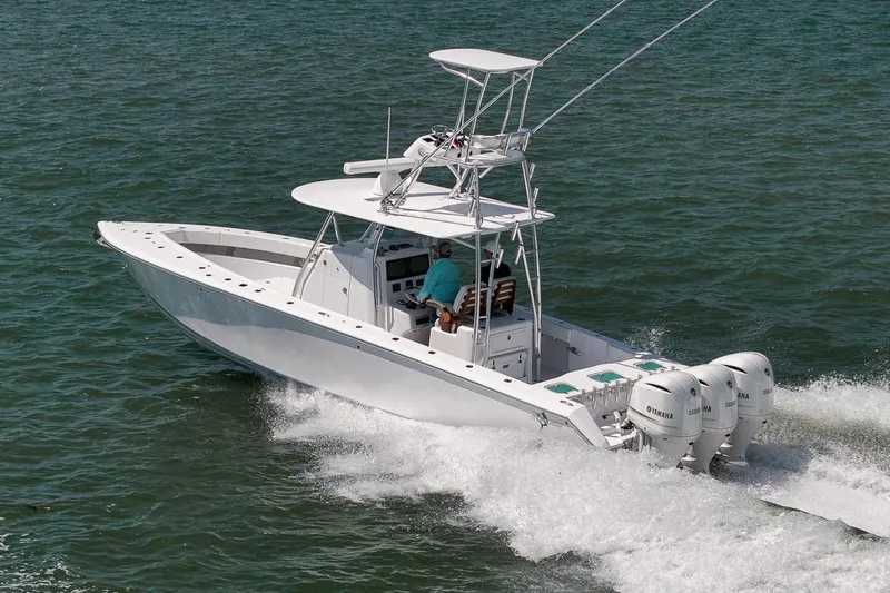 Slide: The Image of 2025 Marquesa 34 boat cruising on open water with triple Yamaha engines. - 10
