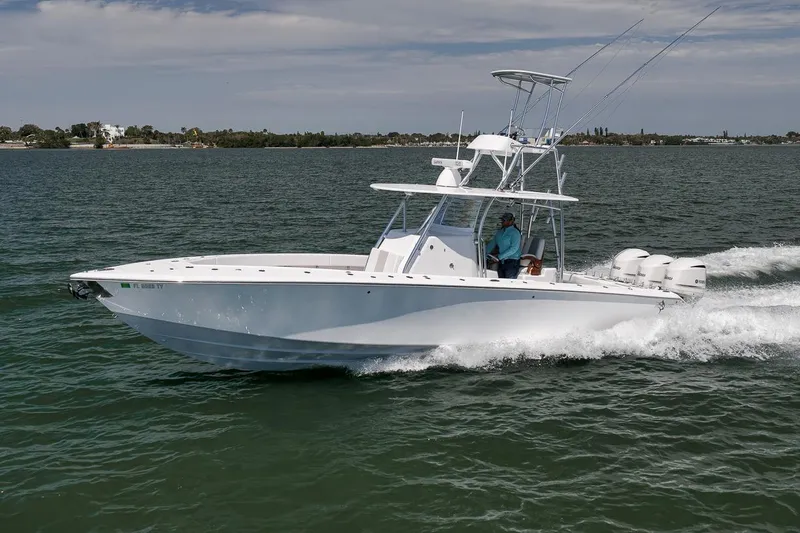Slide: The Image of 2025 Marquesa 34 boat cruising on open water with triple outboard engines. - 13
