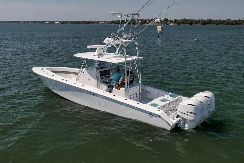 Slide: The Image of 2025 Marquesa 34 boat cruising on calm waters with dual Yamaha engines. - 26