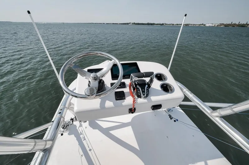 Slide: The Image of Helm of 2025 Marquesa 34 boat with steering wheel and controls on open water. - 42