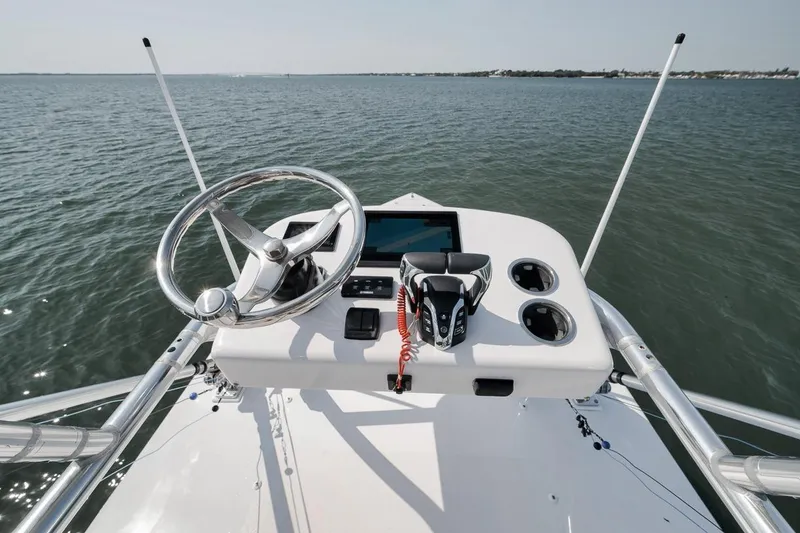Slide: The Image of Helm of 2025 Marquesa 34 boat with steering wheel and controls on open water. - 43
