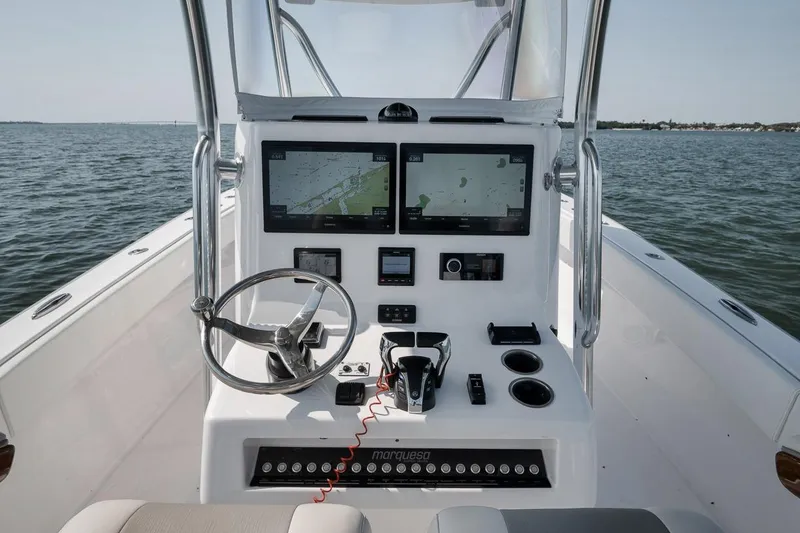 Slide: The Image of Helm of 2025 Marquesa 34 boat with dual navigation screens and steering wheel on open water. - 47