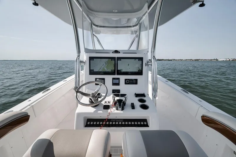 Slide: The Image of Helm of 2025 Marquesa 34 boat with dual screens, steering wheel, and ocean view. - 49