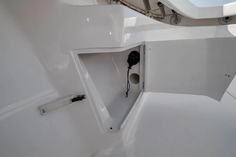 Slide: The Image of Open storage compartment on a 2025 Marquesa 34 boat, showcasing sleek white interior design. - 73
