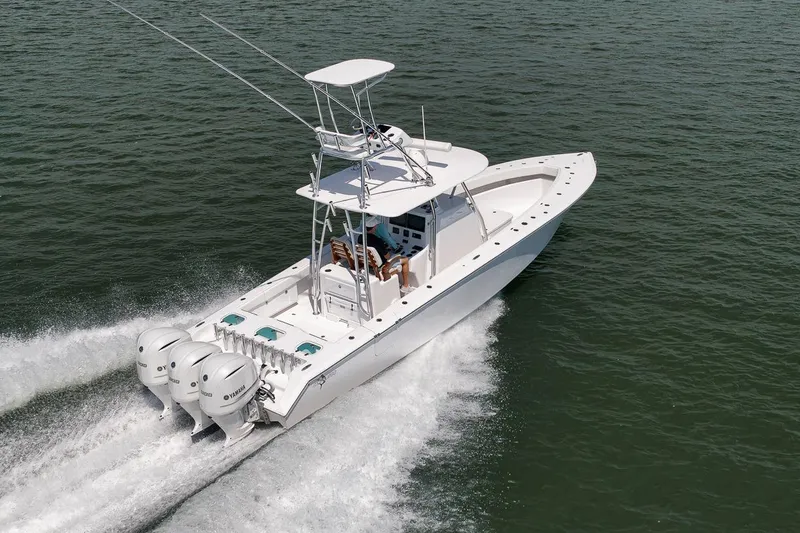 Slide: The Image of 2025 Marquesa 34 boat cruising on water with triple Yamaha outboard engines. - 8