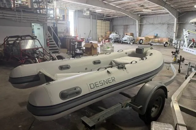 Slide: The Image of Inflatable Desner CL340 boat on trailer in industrial warehouse, 2026 model. - 2
