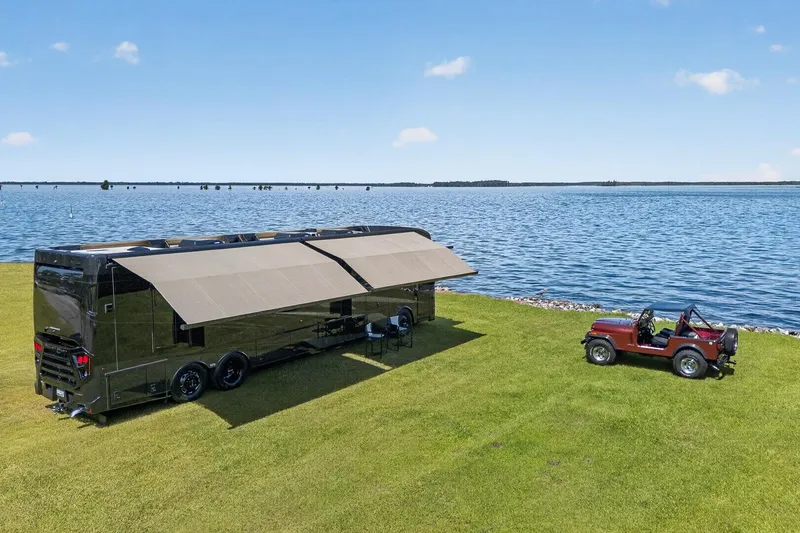 Slide: The Image of 2025 Newmar Dutch Star 4340 RV parked by a serene lakeside with a vintage red jeep. - 34