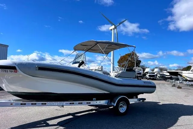 Slide: The Image of 2023 Zodiac N-ZO 680 boat on trailer, parked outdoors under blue sky. - 2