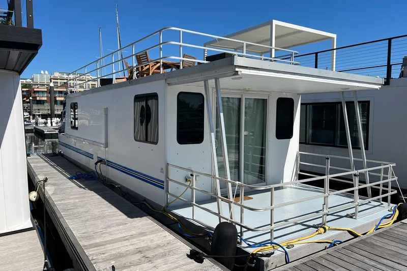 The Image of 2019 Catamaran Cruisers houseboat docked at a marina under clear blue skies. - 1