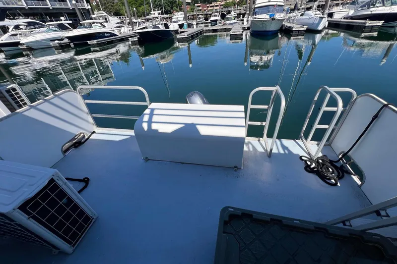 Slide: The Image of 2019 Catamaran Cruisers House Boat docked at marina, featuring spacious deck and railing. - 15