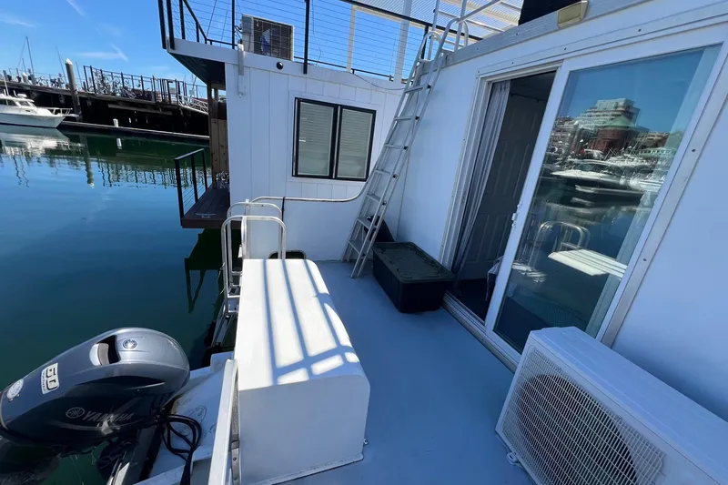 Slide: The Image of 2019 Catamaran Cruisers houseboat with outdoor deck and marina view. - 17