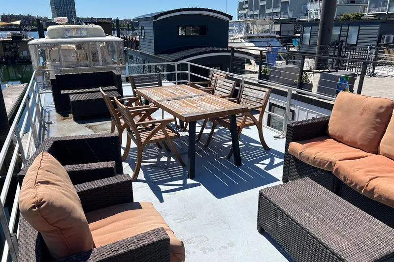 Slide: The Image of 2019 Catamaran Cruisers houseboat deck with outdoor seating and dining area. - 20