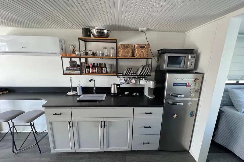 Slide: The Image of Modern kitchen in a 2019 Catamaran Cruisers houseboat with sleek appliances and organized shelving. - 8