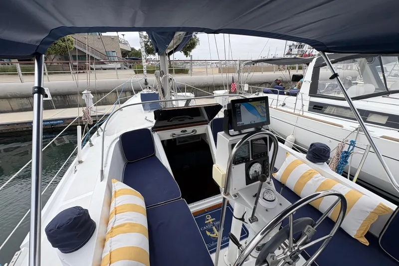 Slide: The Image of 1972 Coronado Yachts 35 Center Cockpit with navigation equipment and striped cushions in marina. - 11
