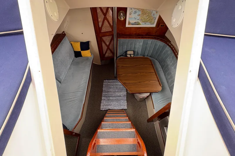 Slide: The Image of Interior of 1972 Coronado Yachts 35 Center Cockpit with cozy seating and wooden table. - 14