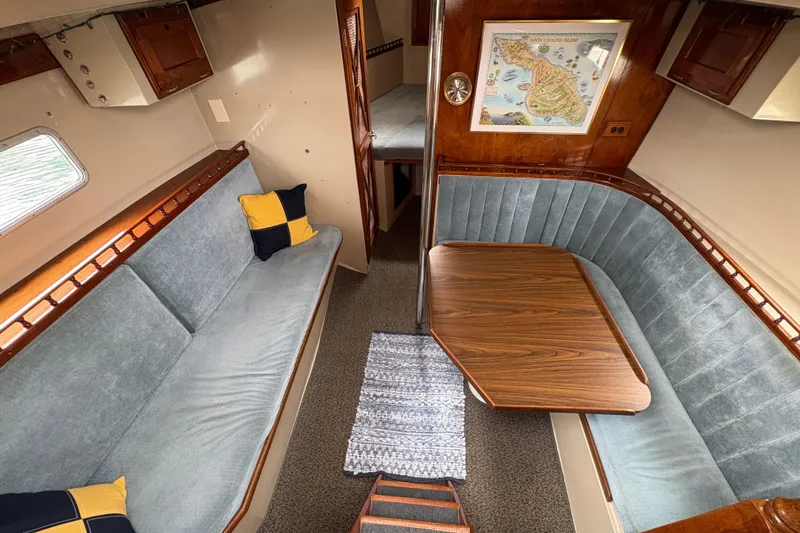 Slide: The Image of 1972 Coronado Yachts 35 Center Cockpit interior with blue seating and wooden table. - 17
