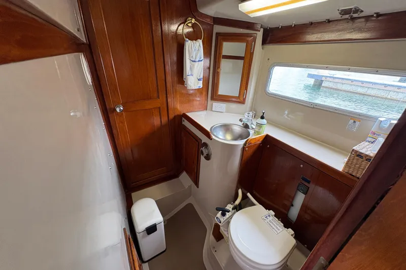 Slide: The Image of 1972 Coronado Yachts 35 Center Cockpit bathroom with wooden cabinetry and stainless steel sink. - 26