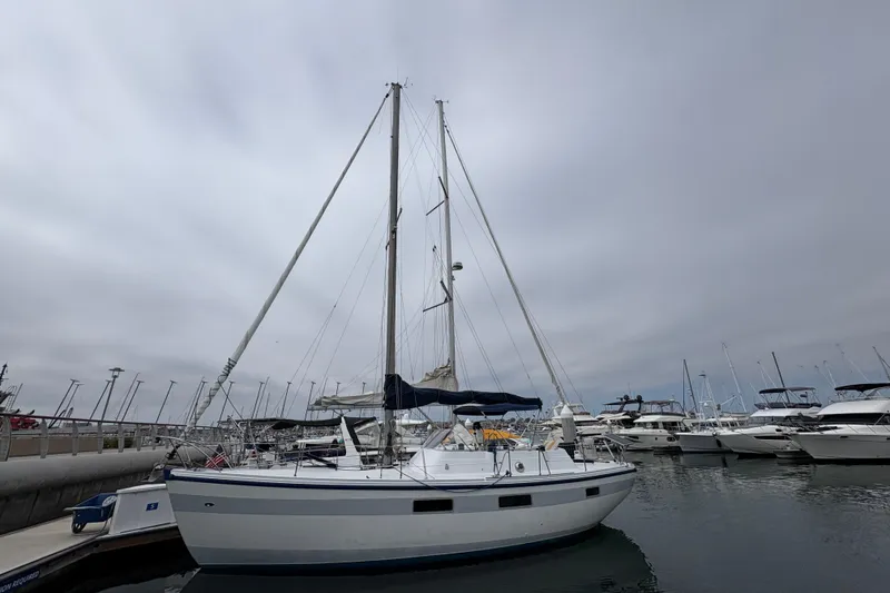 Slide: The Image of 1972 Coronado Yachts 35 Center Cockpit sailboat docked in a marina under cloudy skies. - 5