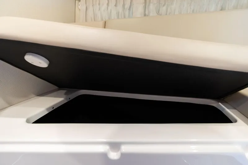 Slide: The Image of 2016 Regal 28 Express boat interior storage compartment with open lid. - 13