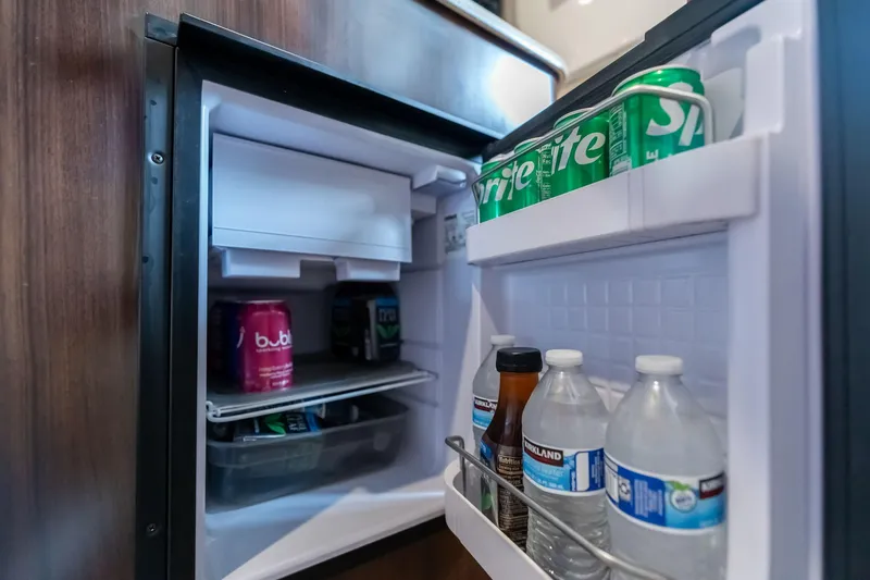 Slide: The Image of Mini fridge stocked with drinks inside a 2016 Regal 28 Express boat. - 18
