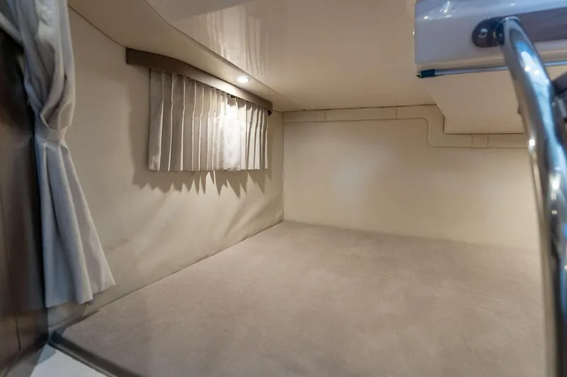 Slide: The Image of Interior cabin of a 2016 Regal 28 Express boat, featuring a cozy sleeping area. - 19