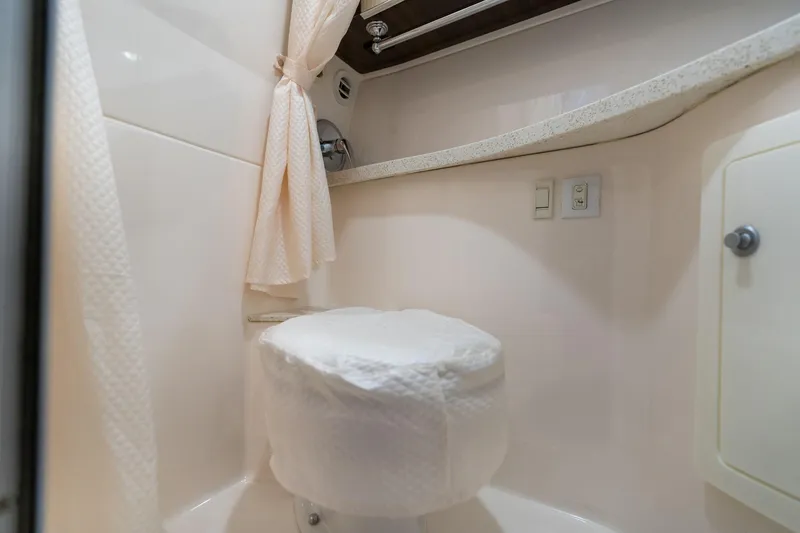 Slide: The Image of 2016 Regal 28 Express boat bathroom interior with toilet and shower curtain. - 23