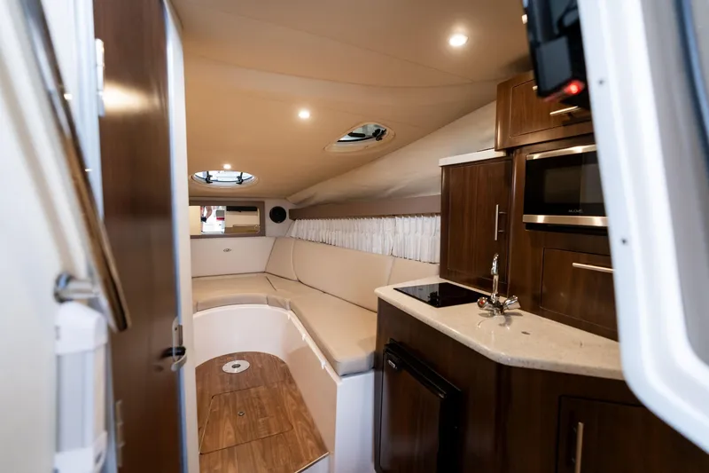 Slide: The Image of Interior of 2016 Regal 28 Express boat with kitchenette and seating area. - 26