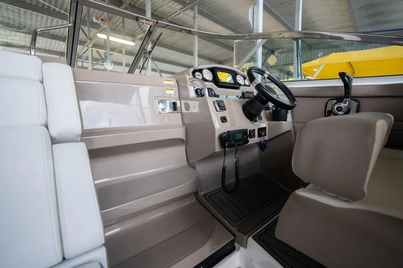 Slide: The Image of 2016 Regal 28 Express boat interior with steering wheel and control panel in a marina setting. - 30