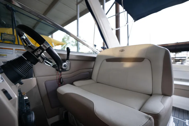 Slide: The Image of 2016 Regal 28 Express boat interior with steering wheel and beige seating. - 31