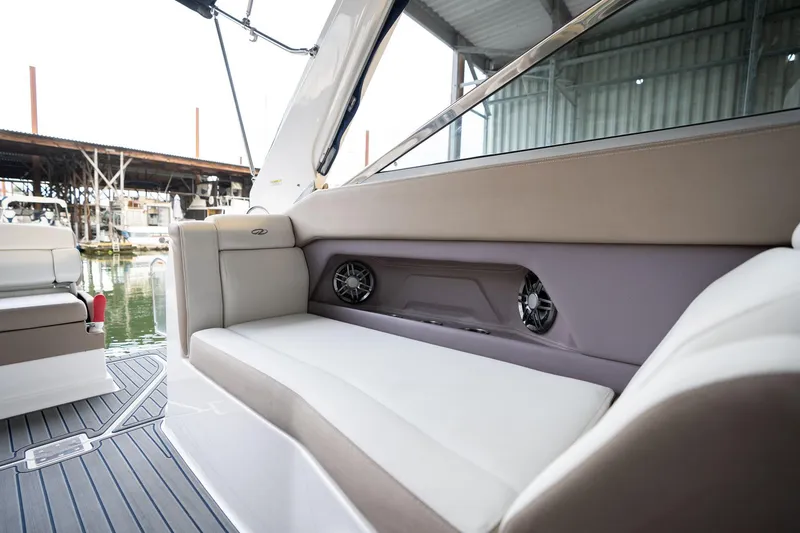 Slide: The Image of 2016 Regal 28 Express boat interior with cushioned seating and built-in speakers. - 34