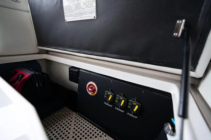 Slide: The Image of Control panel inside 2016 Regal 28 Express boat cabin, featuring switches and storage. - 36