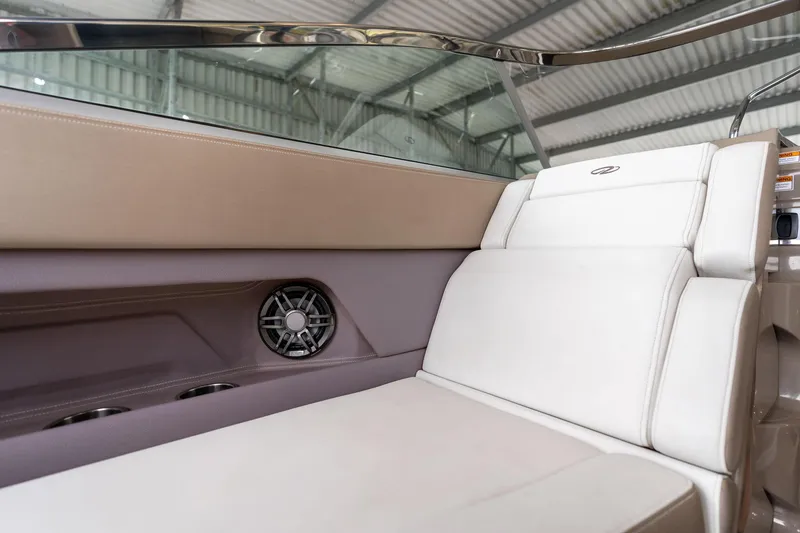 Slide: The Image of Interior seating of 2016 Regal 28 Express boat, featuring white upholstery and speaker. - 37