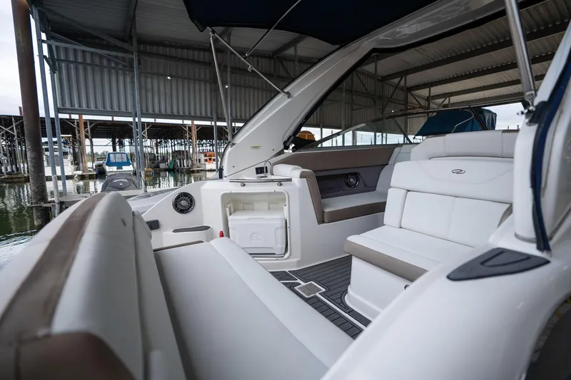 Slide: The Image of 2016 Regal 28 Express boat interior with seating and storage, docked in a covered marina. - 4