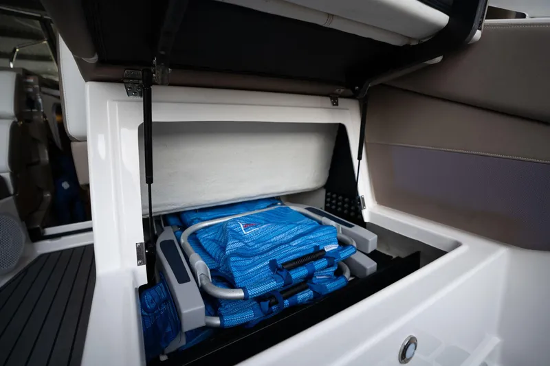Slide: The Image of Storage compartment in a 2016 Regal 28 Express boat with blue life jackets. - 42