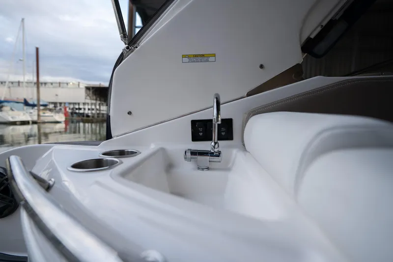 Slide: The Image of 2016 Regal 28 Express boat interior with sink and cup holders. - 44