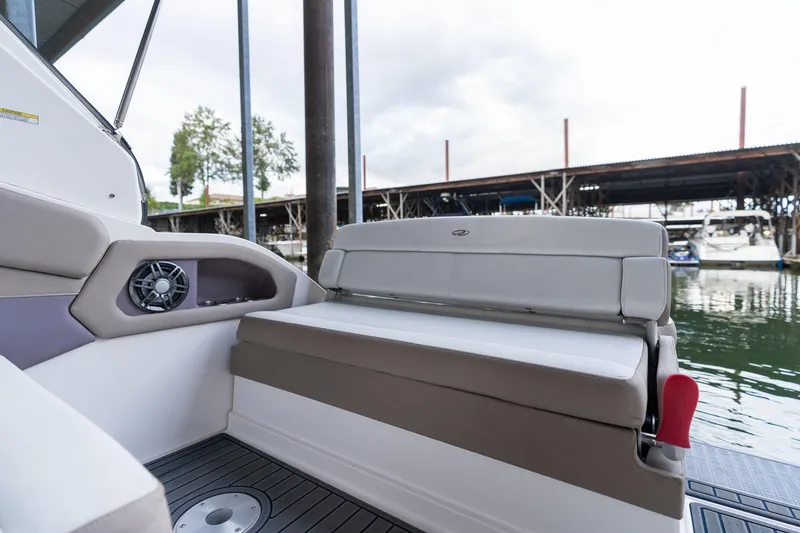 Slide: The Image of 2016 Regal 28 Express boat interior with cushioned seating and speaker, docked by the water. - 46