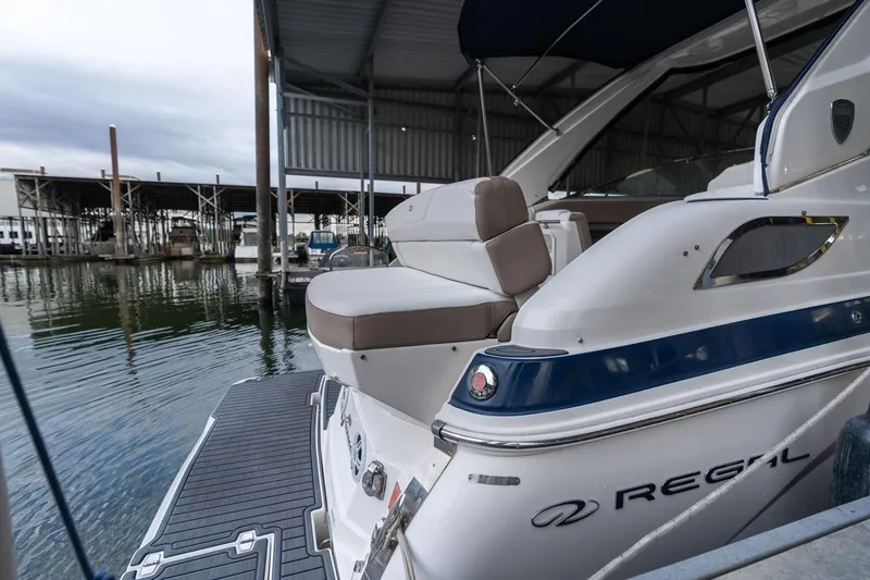 Slide: The Image of 2016 Regal 28 Express boat docked in a marina, showcasing sleek design and comfortable seating. - 47