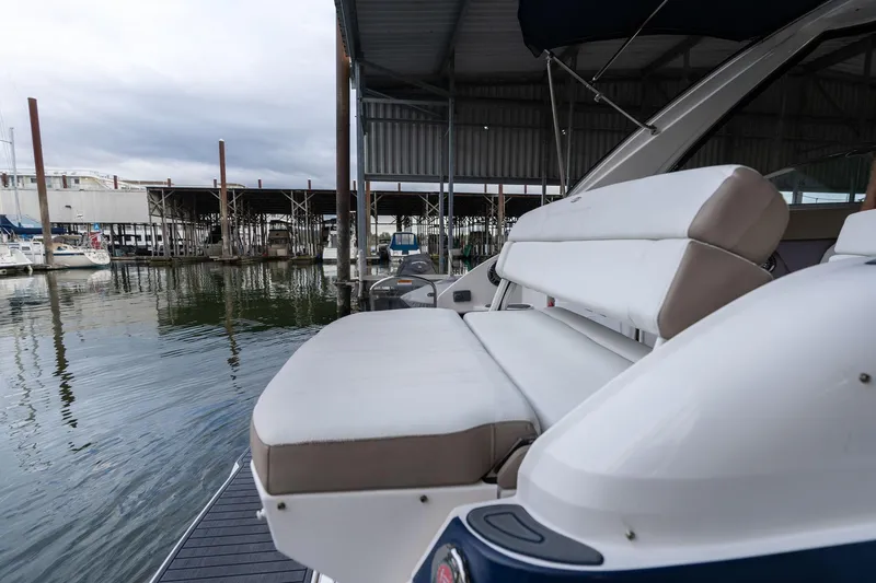 Slide: The Image of 2016 Regal 28 Express boat with cushioned seating at a marina dock. - 48