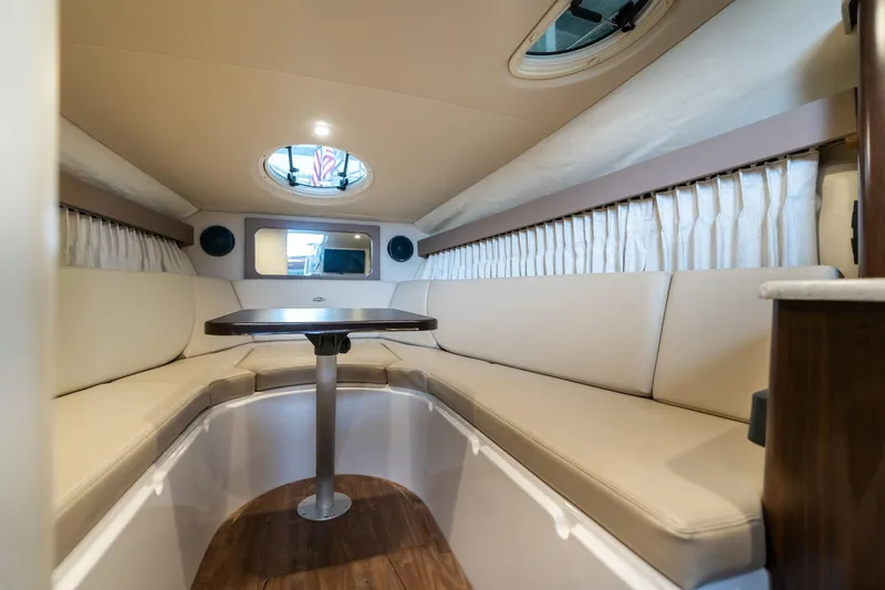 Slide: The Image of Interior of a 2016 Regal 28 Express boat with beige seating and a central table. - 5