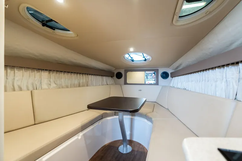 Slide: The Image of 2016 Regal 28 Express cabin interior with beige seating and table. - 6