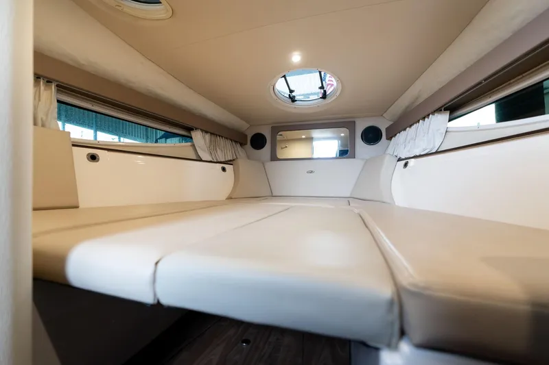 Slide: The Image of Interior cabin of a 2016 Regal 28 Express boat, featuring comfortable seating and porthole. - 9