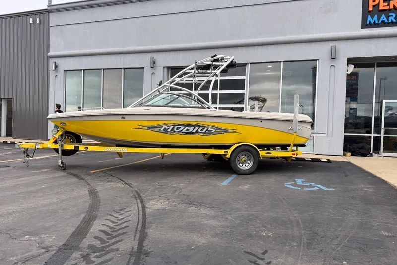 Slide: The Image of 2008 Moomba Mobius LSV boat in yellow on trailer outside a building. - 2