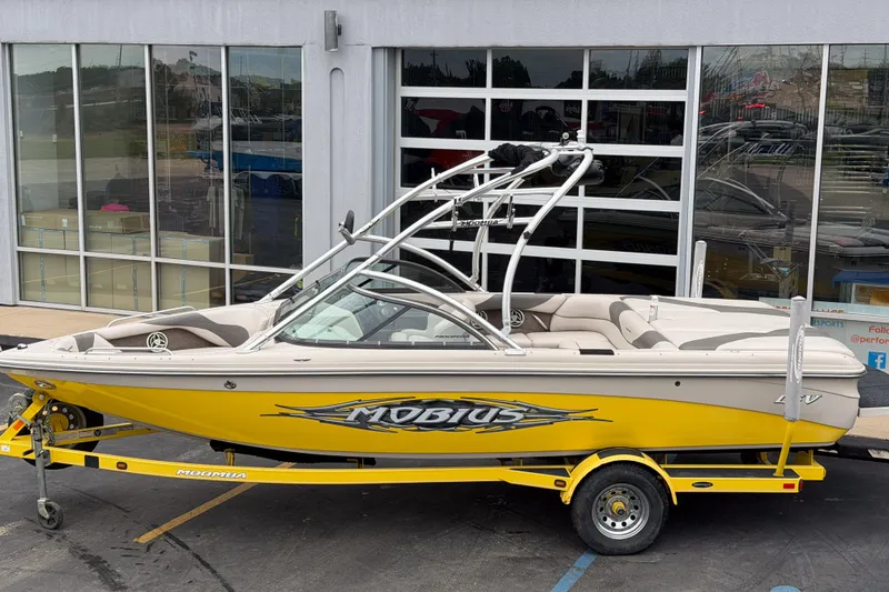 Slide: The Image of 2008 Moomba Mobius LSV boat in yellow, parked on a trailer outside a showroom. - 3