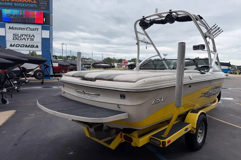 Slide: The Image of 2008 Moomba Mobius LSV boat on trailer at dealership, showcasing rear view and wakeboard tower. - 6