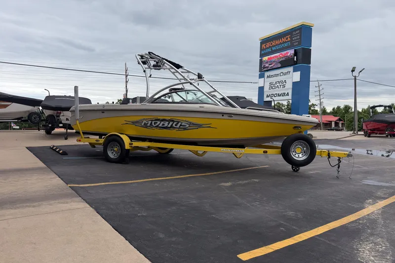 Slide: The Image of 2008 Moomba Mobius LSV boat in yellow on trailer at dealership parking lot. - 7